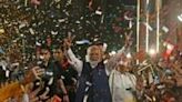 Modi flashes victory signs as he arrives at his BJP party's headquarters