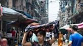 A woman shields herself from the sun as she walks along a Yangon street on a hot day last week