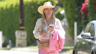 Teddi Mellencamp covers up in a long sleeve shirt and pink pants