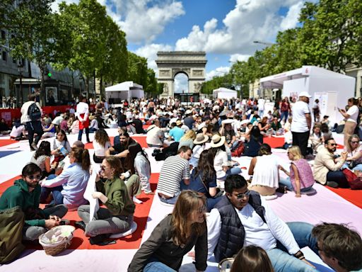 Paris hosted a giant picnic for over 4,000 people on the iconic Champs-Élysées as it tries to attract local customers ahead of the Olympics