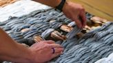 Community bands together to make grocery bags into mats for people who are homeless