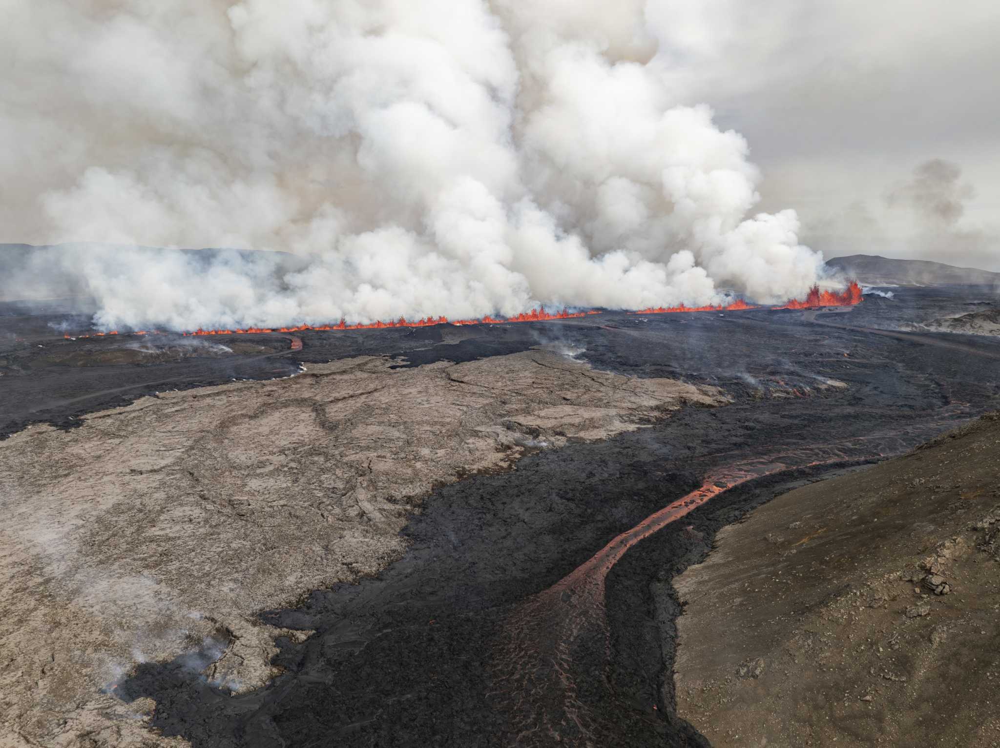 An Iceland volcano spews red streams of lava toward an evacuated town