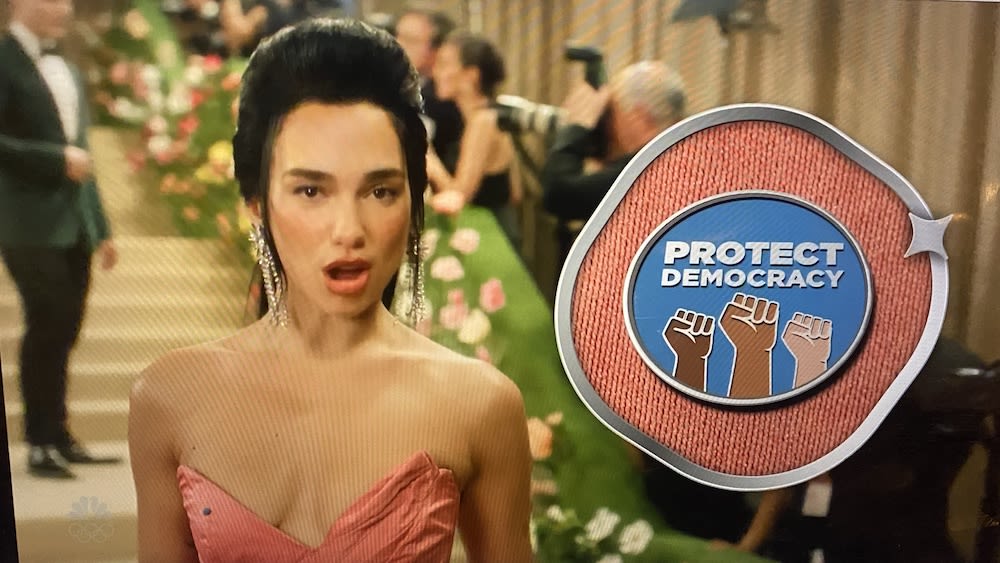 ‘SNL’ Pokes Fun At “Teeny Tiny Statement Pins” Celebrities Wear On Red Carpets With Help Of Host Dua Lipa