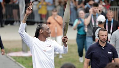 Snoop Dogg carries the Olympic torch before opening ceremony in Paris