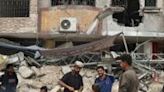 A Palestinian vendor prepares to make falafel sandwiches on a makeshift stall next to the rubble of a destroyed building in Khan Yunis in the southern Gaza Strip