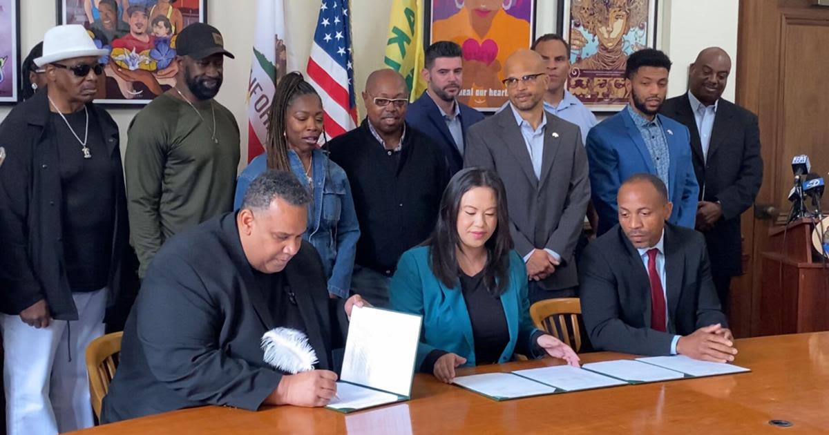 ...Entertainment Group founder Ray Bobbitt, front left, sits alongside Oakland Mayor Sheng Thao and city administrator Jestin Johnson as he signs a term sheet with the city to acquire...