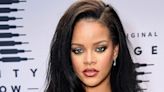 Rihanna wears a sleek black party dress with a *killer* thigh-high slit