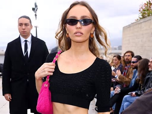 Lily-Rose Depp flaunts her washboard abs in a black crop top and pink mini skirt as she poses at the star-studded Chanel Cruise show in Marseille