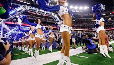 The Dallas Cowboys Cheerleaders skip onto the field during their introduction before a game against the Washington Commanders at AT&T Stadium in Arlington, Texas, on Nov. 23, 2023.