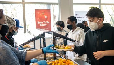 Grupos locales reinventan el almuerzo escolar con alimentos básicos de otras culturas como el congee y el arroz jollof