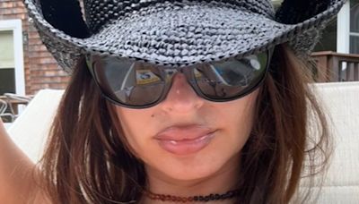 Emily Ratajkowski poses in cow print bikini and cowboy hat