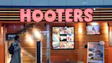 A woman was arrested for assault after coughing in a Hooters owner's face and jumping on bar stool, report says