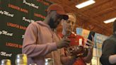 Former UofL basketball star Russ Smith signs limited edition bottles of his bourbon