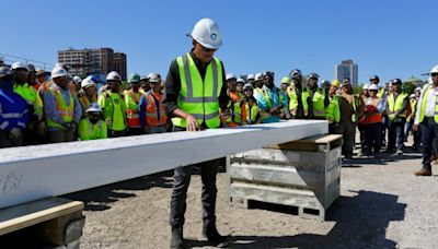 Obama signs steel beam installed on top of presidential center