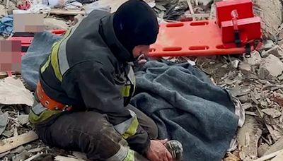 Moment firefighter cries over wife’s body after strike on his home in Ukraine