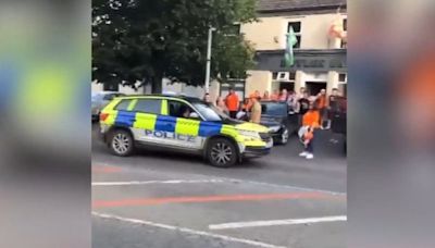 Police celebrate Armagh All-Ireland win with laps of the road waving flags