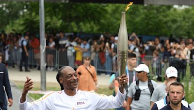 Snoop Dogg lights up Games as he carries the Olympic torch before opening ceremony in Paris