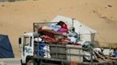 Displaced Palestinians gather their belongings on the back of a truck as they flee al-Mawasi to a safer area in Rafah in the southern Gaza Strip