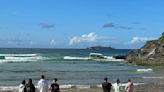 Whipped out to sea! Ice cream van is seen being buffeted by the waves