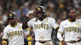 ...The San Diego Padres' Jurickson Profar, right, celebrates with Fernando Tatis Jr., middle, and Luis Arraez, left, after they scored on a throwing error during the fifth...