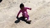 Adorable moment toddler, two, tries to run away from her shadow