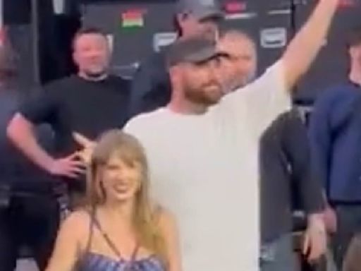 Travis Kelce and Taylor Swift hold hands as they leave Eras Tour stage