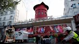 Moulin Rouge's famous windmill sails FALL OFF and crash onto street