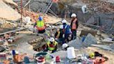 Rescuers contact some workers alive in the rubble of a deadly building collapse in South Africa