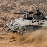 Israeli soldiers man an armoured vehicle operating near the border with the Gaza Strip