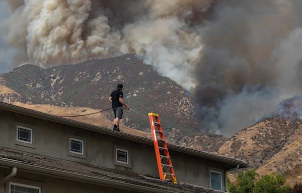 Residents flee as California and Nevada wildfires get dangerously close and forecasters warn of record heat