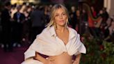 Sienna Miller rocks two-piece, caresses baby bump at London Fashion Week