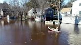 Residents seen in canoes after broken dam causes extensive flooding in East Bridgewater