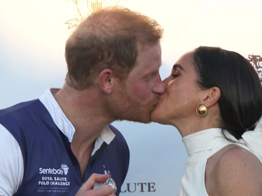 El príncipe Harry y Meghan Markle se lo pasan en grande con un apasionado beso en medio de la crisis familiar