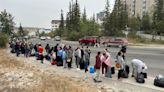 People wait in line overnight for evacuation flights out of Yellowknife