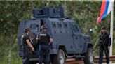 Kosovar police surround a village after Serb gunmen storm a monastery in violence that has killed 4
