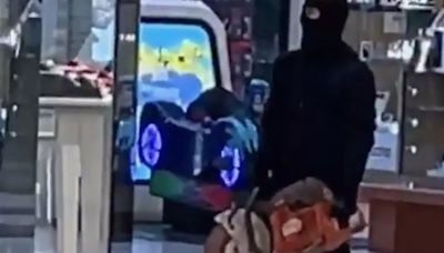 Shock moment masked robber brandishes circular saw in shopping centre