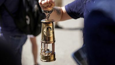 La llama olímpica viaja al estilo 'vintage', protegida por una linterna de minero