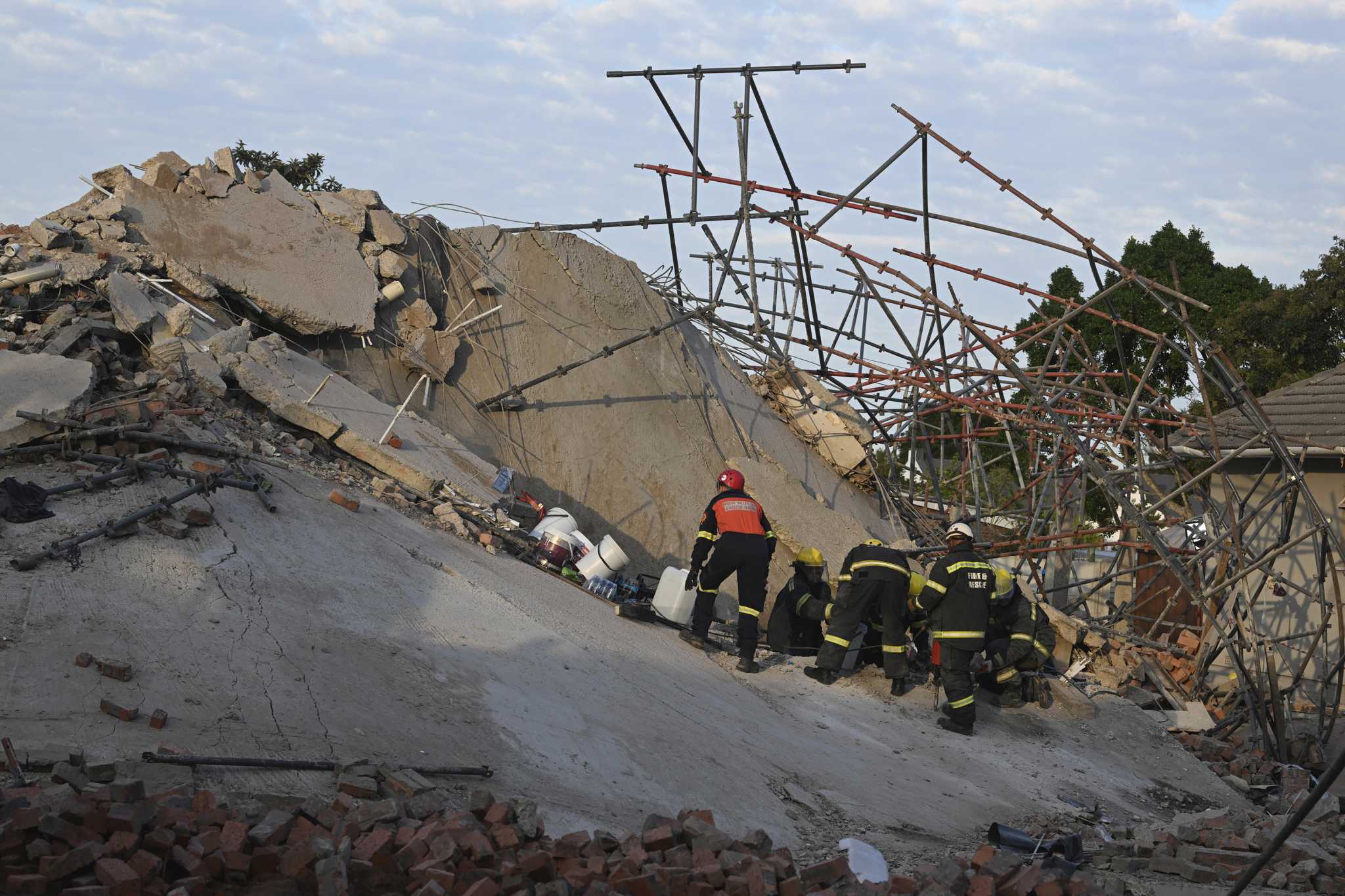 Rescuers bring out survivors from the rubble a day after a deadly building collapse in South Africa