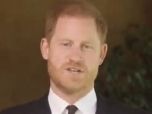 Clean-cut Prince Harry dons his medals for video from the back door of his Montecito mansion to present a soldier of the year award to US combat medic