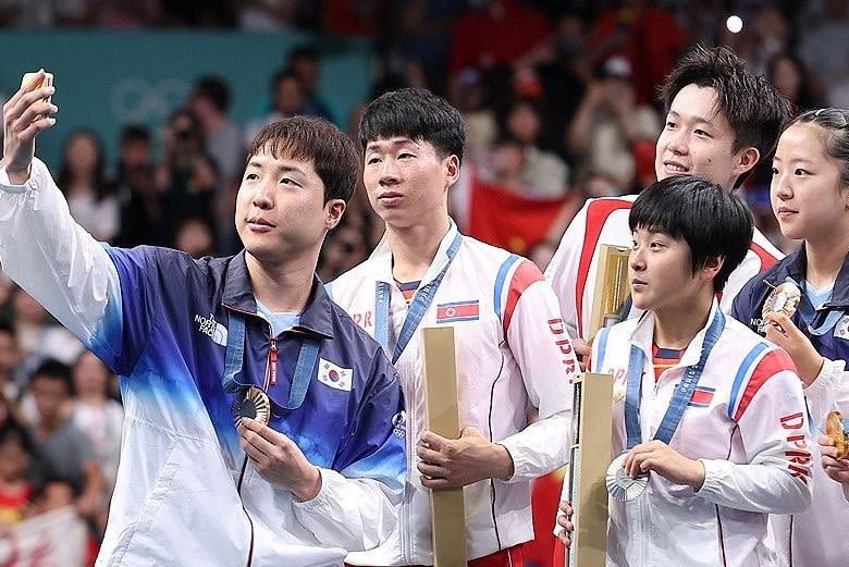 North, South Korea share podium, selfie in rare Olympic moment