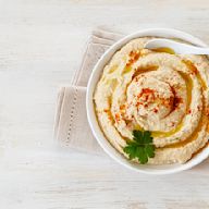 A dip made from cooked, mashed chickpeas blended with tahini, olive oil, lemon juice, garlic, and other seasonings, often served with pita bread or vegetables. Originated in the Middle East and is now popular worldwide.