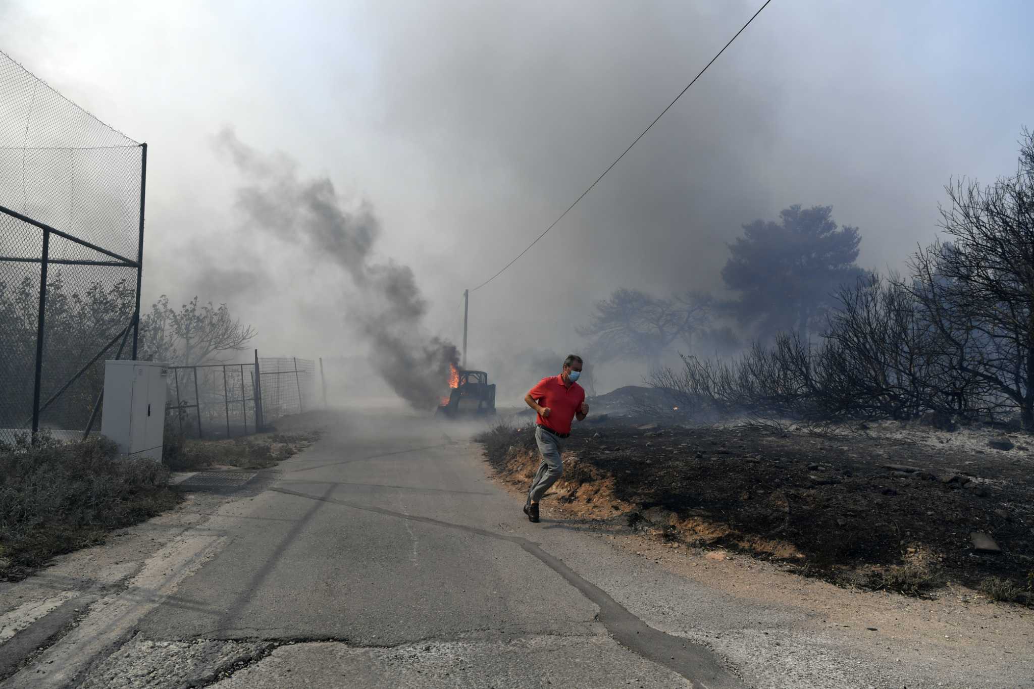 Drop in winds offers hope as firefighters battle huge wildfire on fringes of Athens. 1 person dead