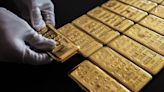 Gold pulls back from record peak as dollar gains