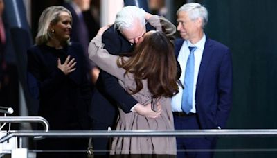 Julian Assange passionately kisses wife and waves to supporters after landing back in Australia