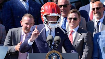 President Joe Biden puts on gifted Chiefs helmet at White House presentation