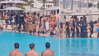 Armed police storm Marbella beach club and order people out of the pool