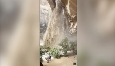 Climber rappels next to raging muddy waterfall sparked by flash floods in Utah