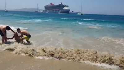 Tourists swept off their feet as huge swell crashes over Mykonos beach