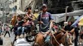 A man flees with children and belongings from the Jabalia camp for Palestinian refugees in the northern Gaza Strip on May 11, 2024