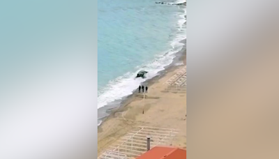 BMW nearly swept away during bizarre drunken photo stunt on beach